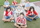 Un grupo de niños posan sobre el césped del Vicente Calderón en una de las visitas al estadio.